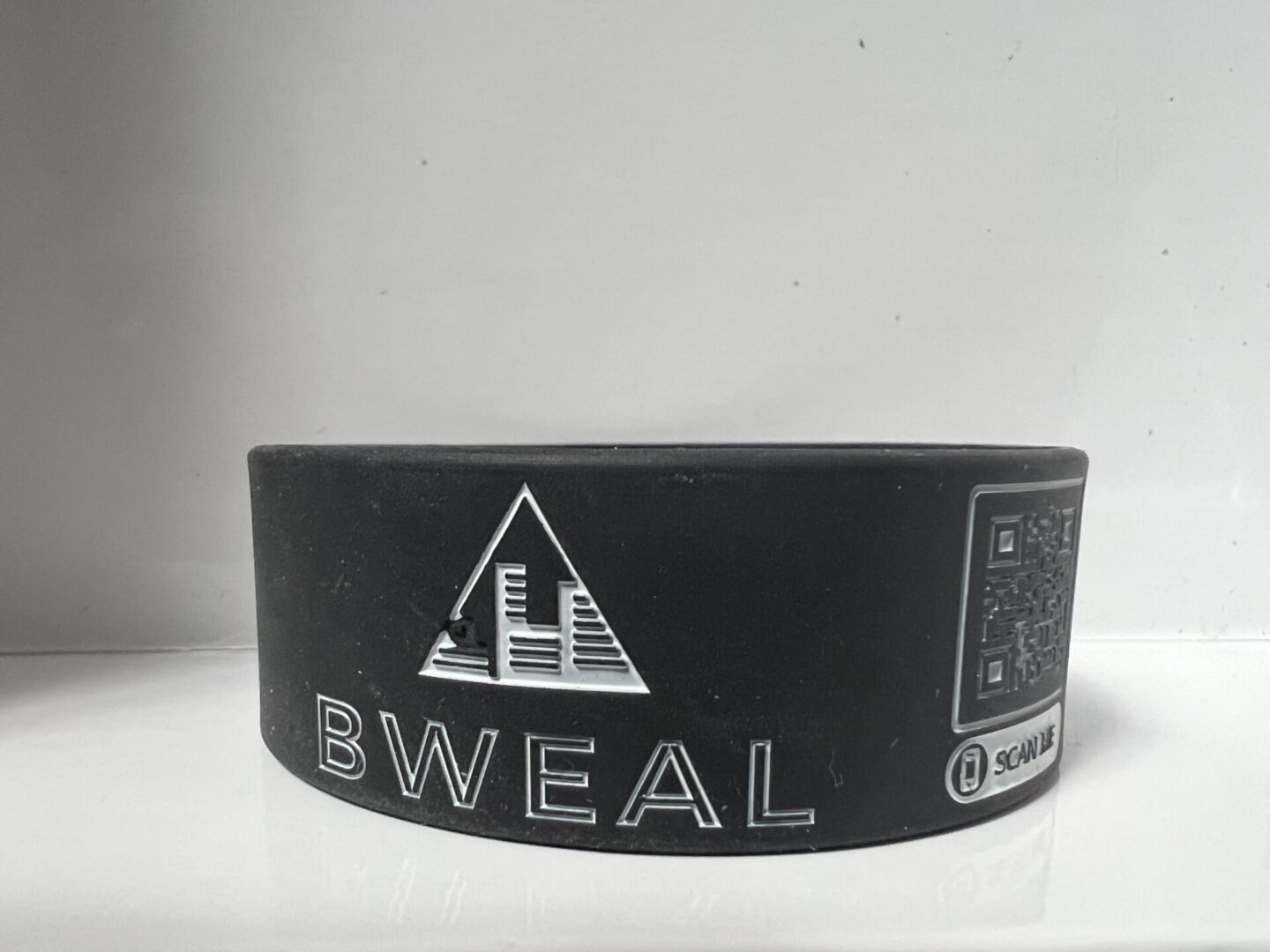 A black wristband with the words bweal on it.